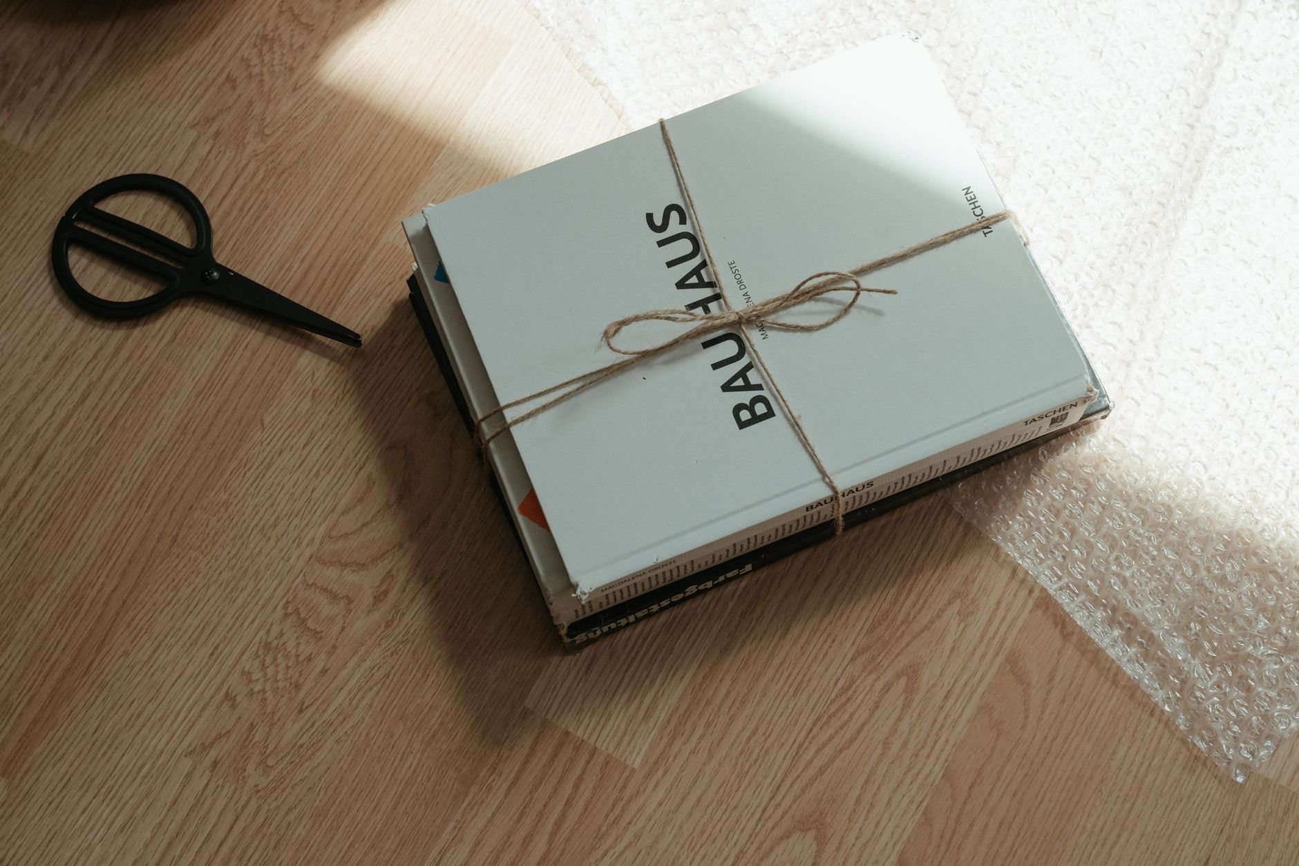Bundle of books wrapped in twine resting on a wooden surface